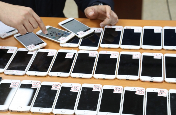 2017년 12월27일 오전 서울 마포 경찰서에서 서울지방경찰청 국제범죄 수사대 수사관들이 제주에서 대만인이 운영한 중국인 상대 대규모 보이스피싱 콜센터를 검거하고 압수한 증거품을 조사하고 있다. ⓒ 연합뉴스