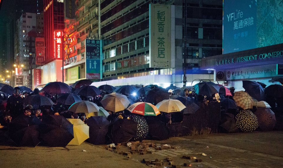 11월19일 새벽 홍콩 야우마테이 인근에서 무장경찰과 대치 중인 시위대가 우산을 방패 삼아 막고 있다.