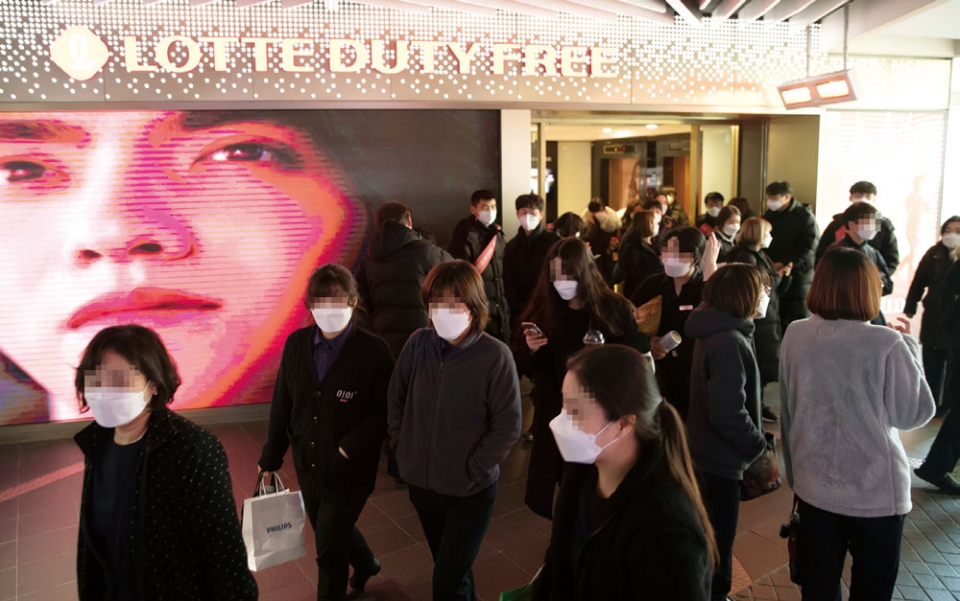 서울 중구 롯데백화점 명동본점이 코로나19 확진자 방문으로 2월7일 오후부터 문을 닫자 같은 건물의 롯데면세점 손님들이 직원 안내를 받으며 건물에서 나오고 있다. ⓒ연합뉴스