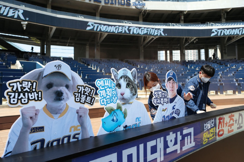 프로야구 팬들의 신청을 받아 관중석에 사진을 채우기로 결정한 NC 다이노스 구단이 4월29일 경남 창원NC파크에서 열리는 롯데-NC 연습경기에 앞서 관중석에 사진을 부착하고 있다. ⓒ연합뉴스