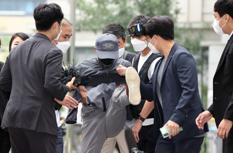 위치추적 전자장치(전자발찌) 훼손 전후로 여성 2명을 잇달아 살해한 혐의를 받는 강아무개씨가 8월31일 서울동부지법에서 열리는 영장실질심사에 출석하며 마이크를 든 취재진을 향해 발을 차고 있다. ⓒ 연합뉴스