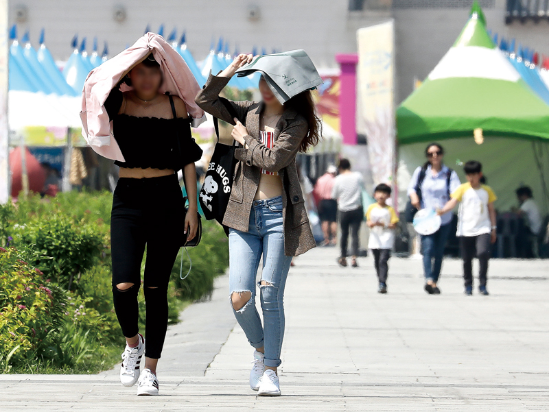 자외선이 강한 여름철, 서울 광화문광장을 지나는 시민들이 옷가지 등으로 강한 햇빛을 차단하고 있다.ⓒ시사저널 사진자료