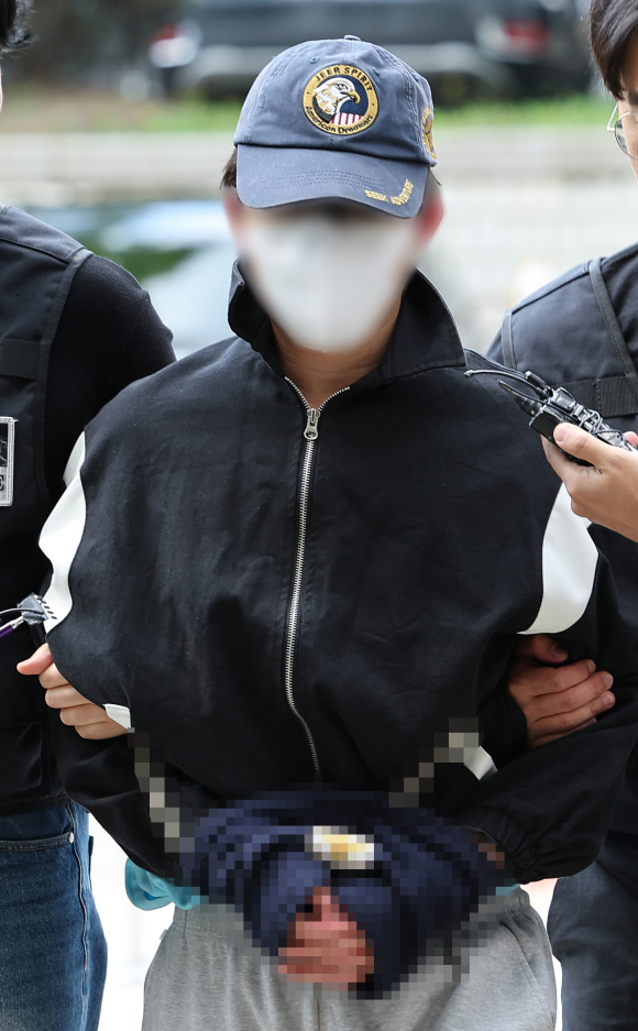 강남역 인근 건물 옥상에서 여자친구를 흉기로 살해한 혐의(살인)를 받는 최아무개(25)씨가 5월8일 서울 서초구 서울중앙지방법원에서 열린 구속 전 피의자 심문(영장실질심사)에 출석하고 있다. ⓒ 연합뉴스