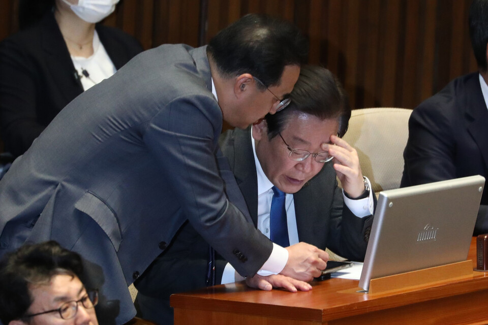 더불어민주당 이재명 대표가 지난해 3월 국회에서 열린 본회의에서 휴대폰을 보면서 대화를 나누고 있다. ⓒ시사저널 박은숙