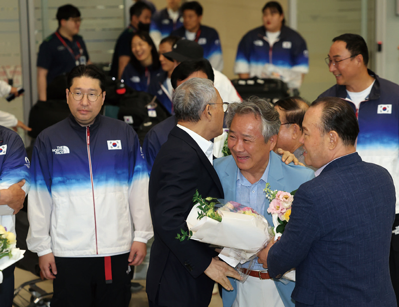 이기흥 대한체육회장이 8월13일 인천국제공항 제2여객터미널을 통해 귀국해 유인촌 문화체육관광부 장관과 인사를 나누고 있다. ⓒ연합뉴스