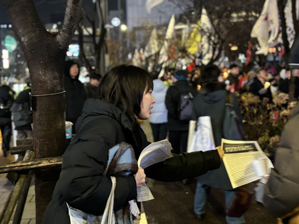 12월5일 서울 광화문역 인근에서 열린 ‘윤석열 퇴진 시민대회’에 참여한 최세윤씨(25)가 윤석열 대통령의 비상계엄을 비판하는 입장문을 시민에게 나눠주고 있다. ⓒ시사저널 정윤경