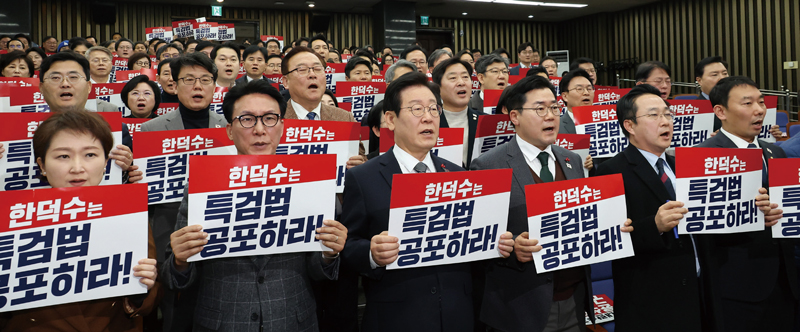 더불어민주당의 이재명 대표(앞줄 왼쪽 세 번째)와 박찬대 원내대표(앞줄 왼쪽 네 번째) 등 의원들이 2024년 12월24일 국회에서 열린 의원총회에 앞서 ‘한덕수는 특검법 공포하라!’라고 적힌 손팻말을 들고 구호를 외치고 있다. ⓒ연합뉴스