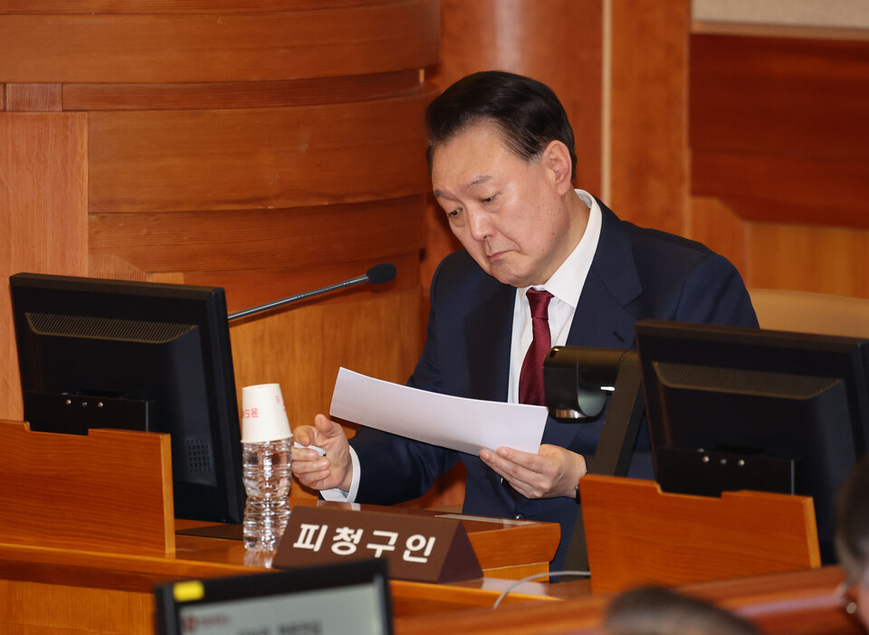 윤석열 대통령이 1월23일 서울 종로구 헌법재판소에서 열린 탄핵심판 4차 변론에 출석해 메모지를 살펴보고 있다. ⓒ연합뉴스