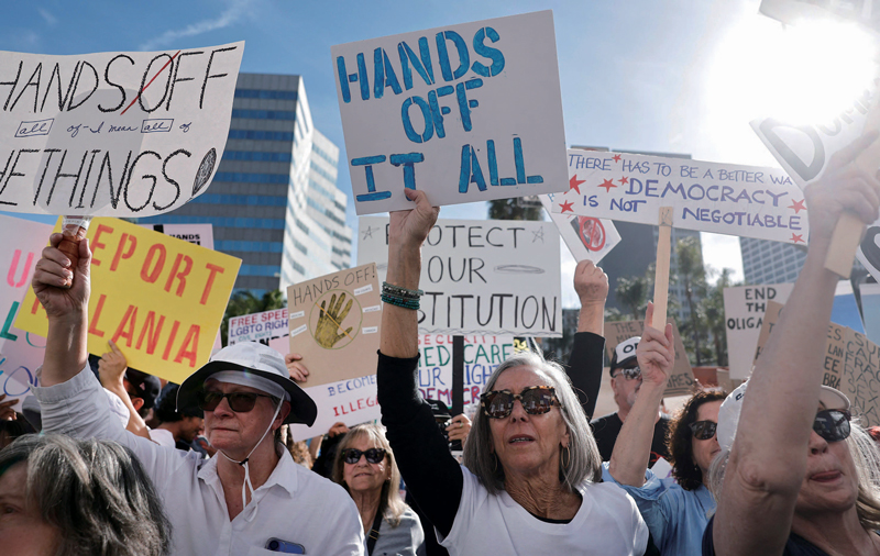 4월5일 미국 캘리포니아주 로스앤젤레스에서 트럼프 대통령의 국정 운영에 반대하는 시위대가 행진하고 있다. 시위자들은 연방정부 구조조정, 이민자 추방, 고율 관세 부과를 중단하라는 의미로 ‘손을 떼라(Hands off)’라는 구호를 외쳤다. 시위 주최 측에 따르면, 이날 미국 1400개 지역에서 약 60만 명이 시위에 참여했다. ⓒAFP 연합