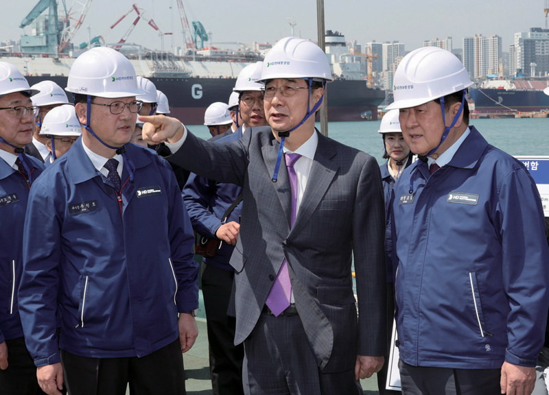 한덕수 대통령 권한대행(가운데)이 4월16일 HD현대중공업 울산조선소에서 HD현대중공업 권오갑 회장(오른쪽) 등과 정조대왕급 2번함 ‘다산정약용함’ 설명을 듣고 있다. ⓒ연합뉴스