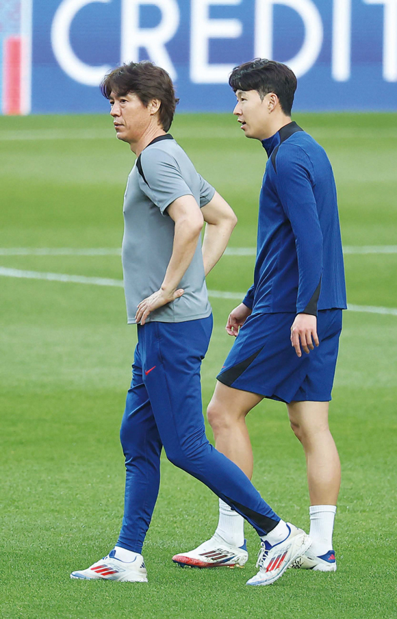 대한민국 축구 국가대표팀 홍명보 감독(왼쪽)과 손흥민이 쿠웨이트와의 2026 북중미 월드컵 아시아 3차 예선 최종전을 하루 앞둔 6월9일 서울월드컵경기장에서 훈련 중 대화를 나누고 있다. ⓒ연합뉴스