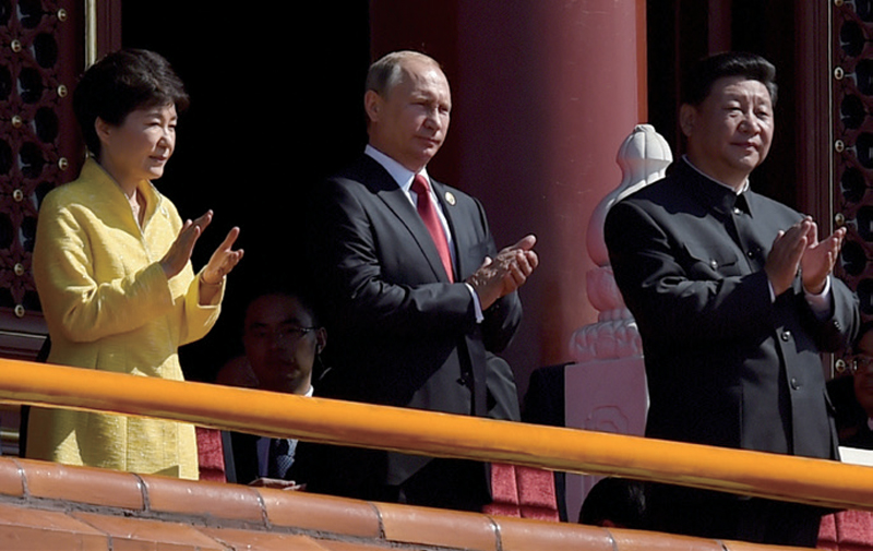 2015년 9월3일 일본의 제2차 세계대전 항복 70주년을 기념하는 군사 퍼레이드에서 당시 한국의 박근혜 대통령(왼쪽)이 블라디미르 푸틴 러시아 대통령(가운데), 시진핑 중국 국가주석(오른쪽)과 함께 박수를 치고 있다. ⓒAP 연합